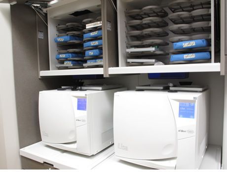 Two white appliances are sitting on a counter in a cabinet.