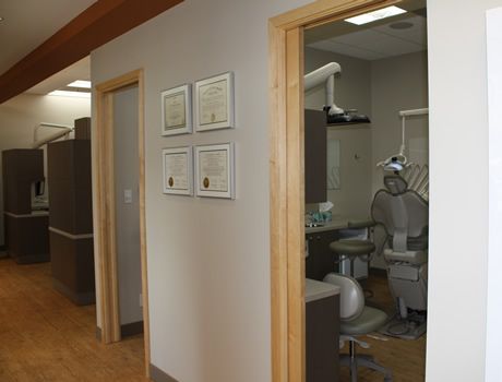 A hallway leading to a dental office with a dental chair.