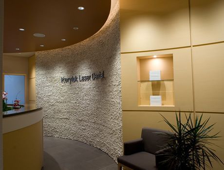 A waiting room with a curved wall and a chair