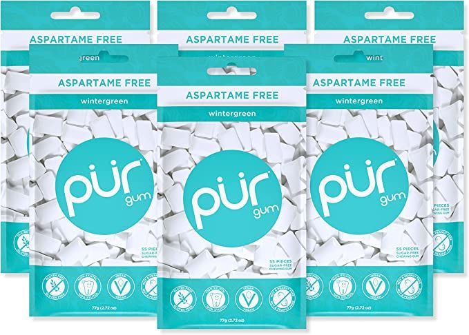 Three bags of pur gum are sitting next to each other on a table.