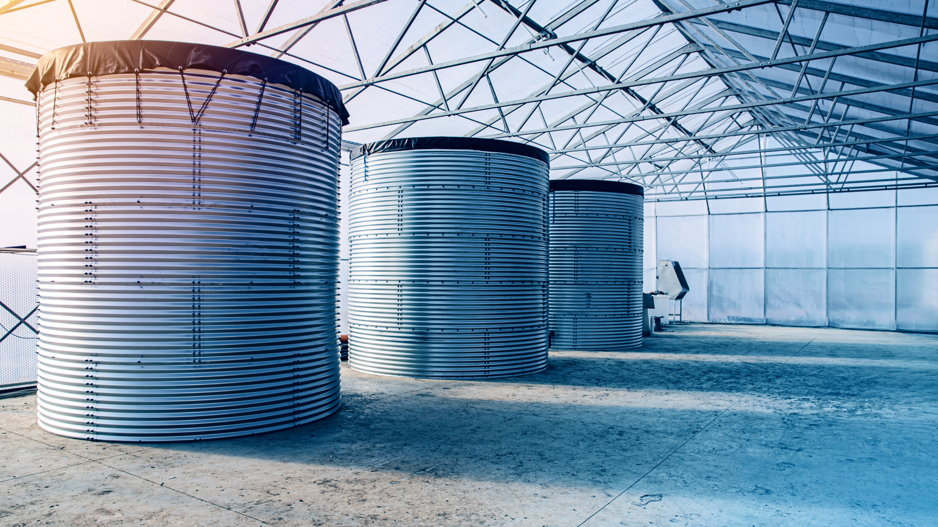 A stone well with a watering can and potted plants in a garden.