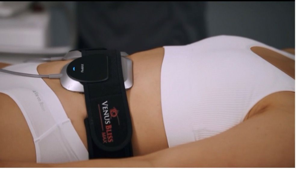 A woman is laying down with a device on her stomach.