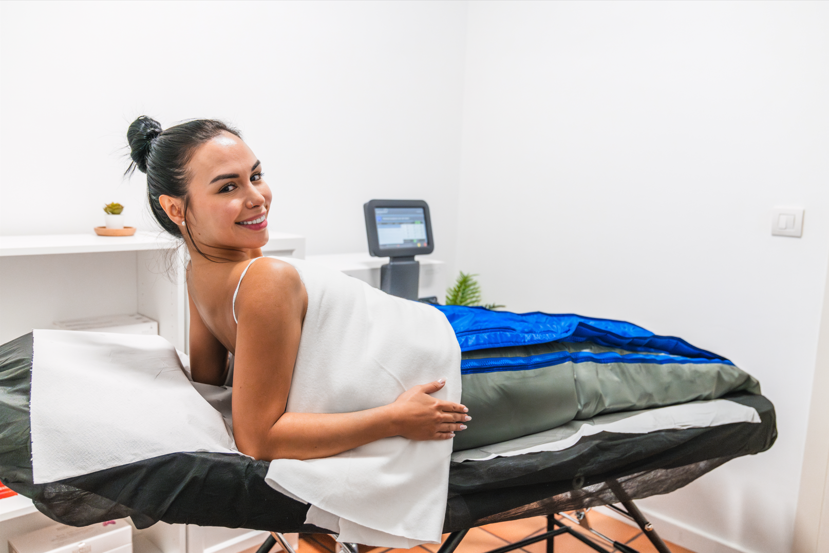 A woman is laying on a massage table in a spa.