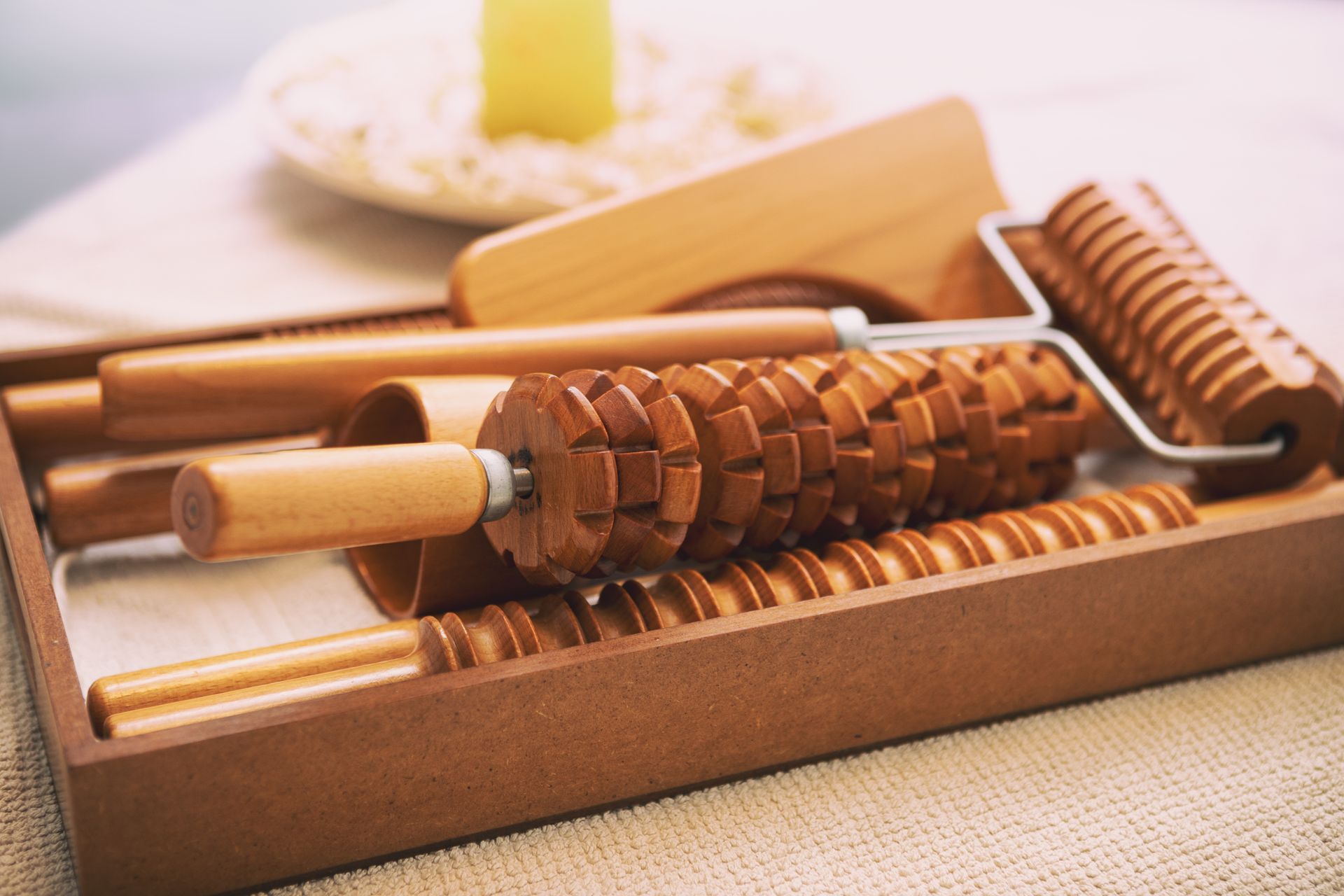 A wooden massage roller is sitting on top of a wooden box.