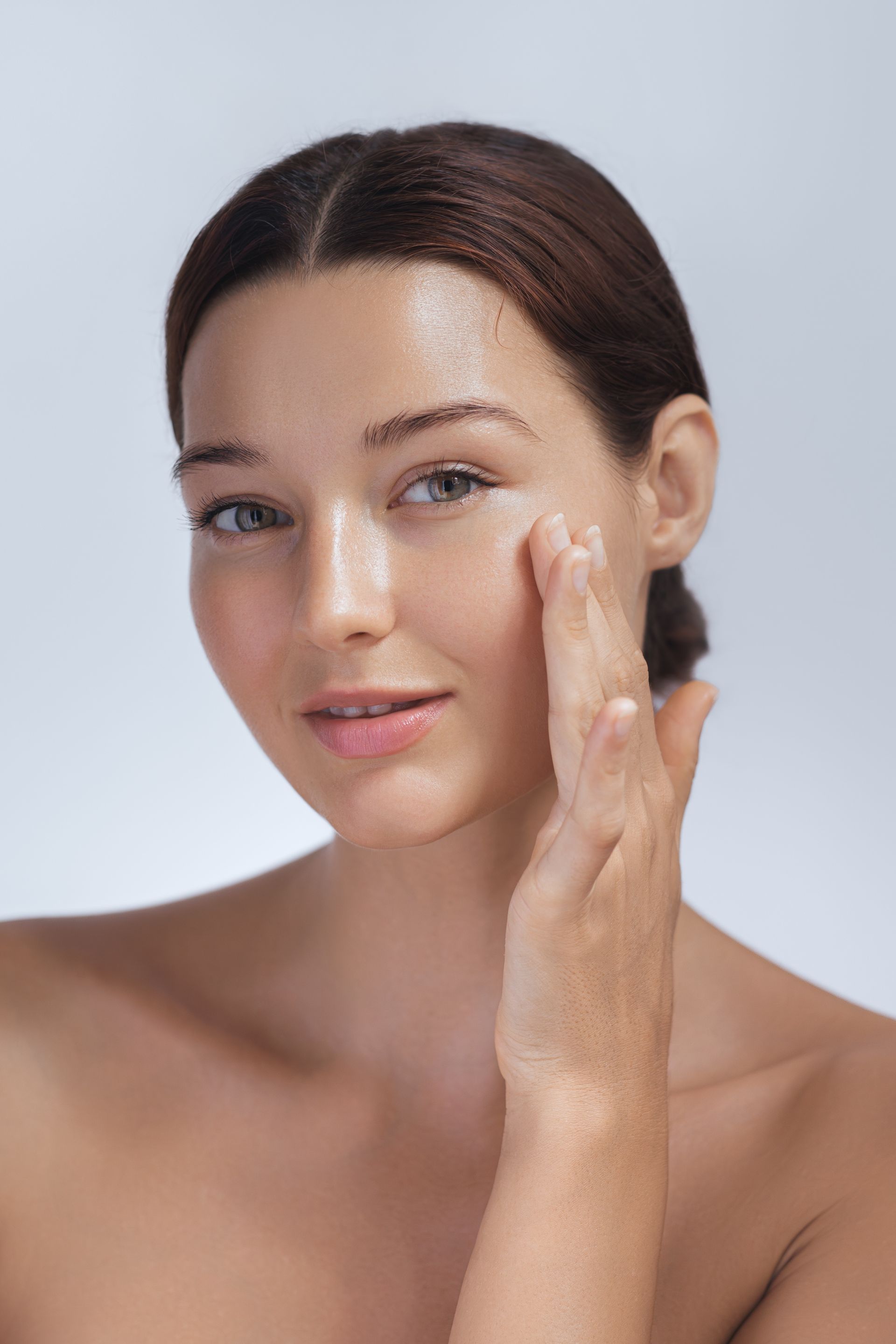 A woman is applying a cream to her face.