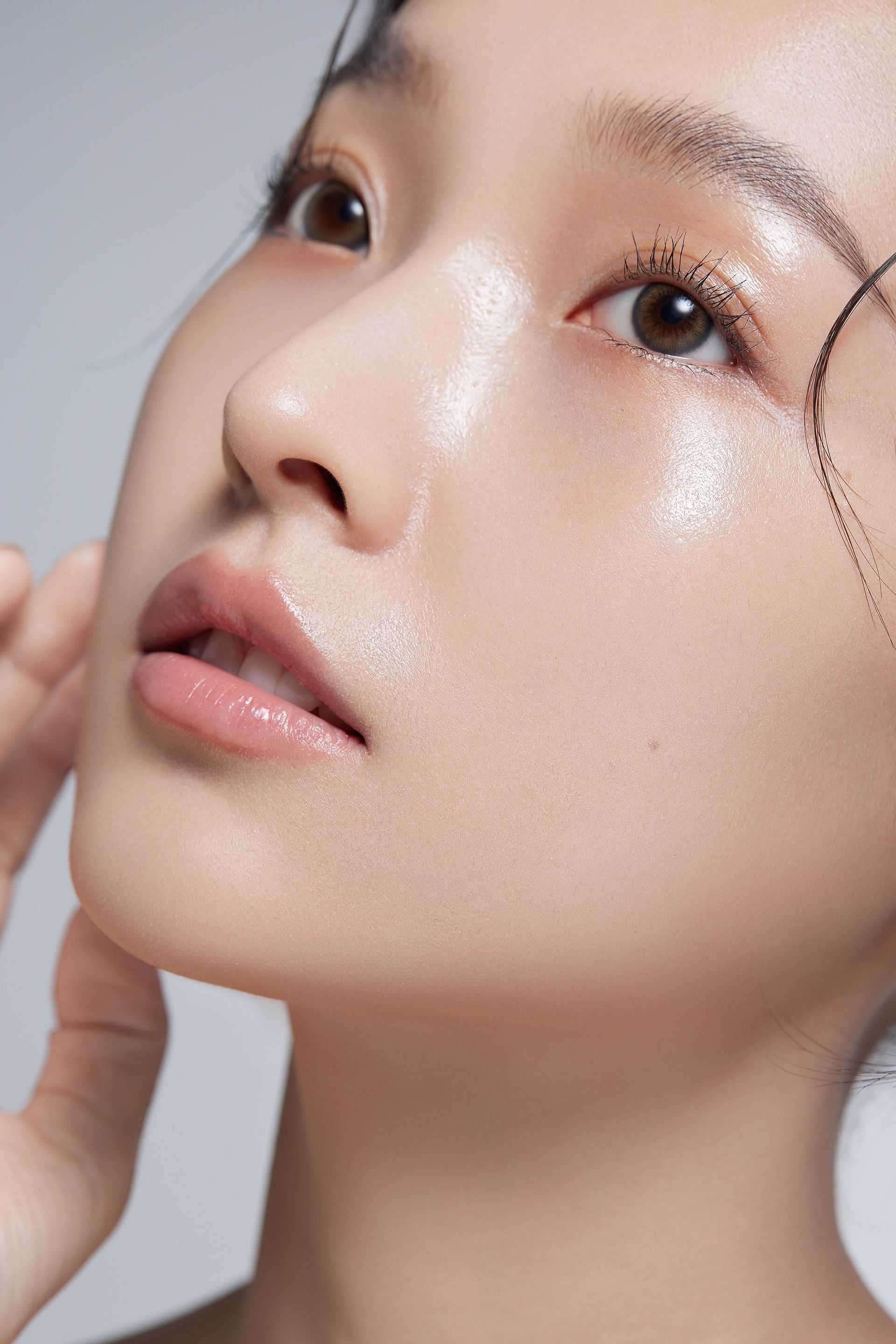 A close up of a woman 's face with a hand on her chin.