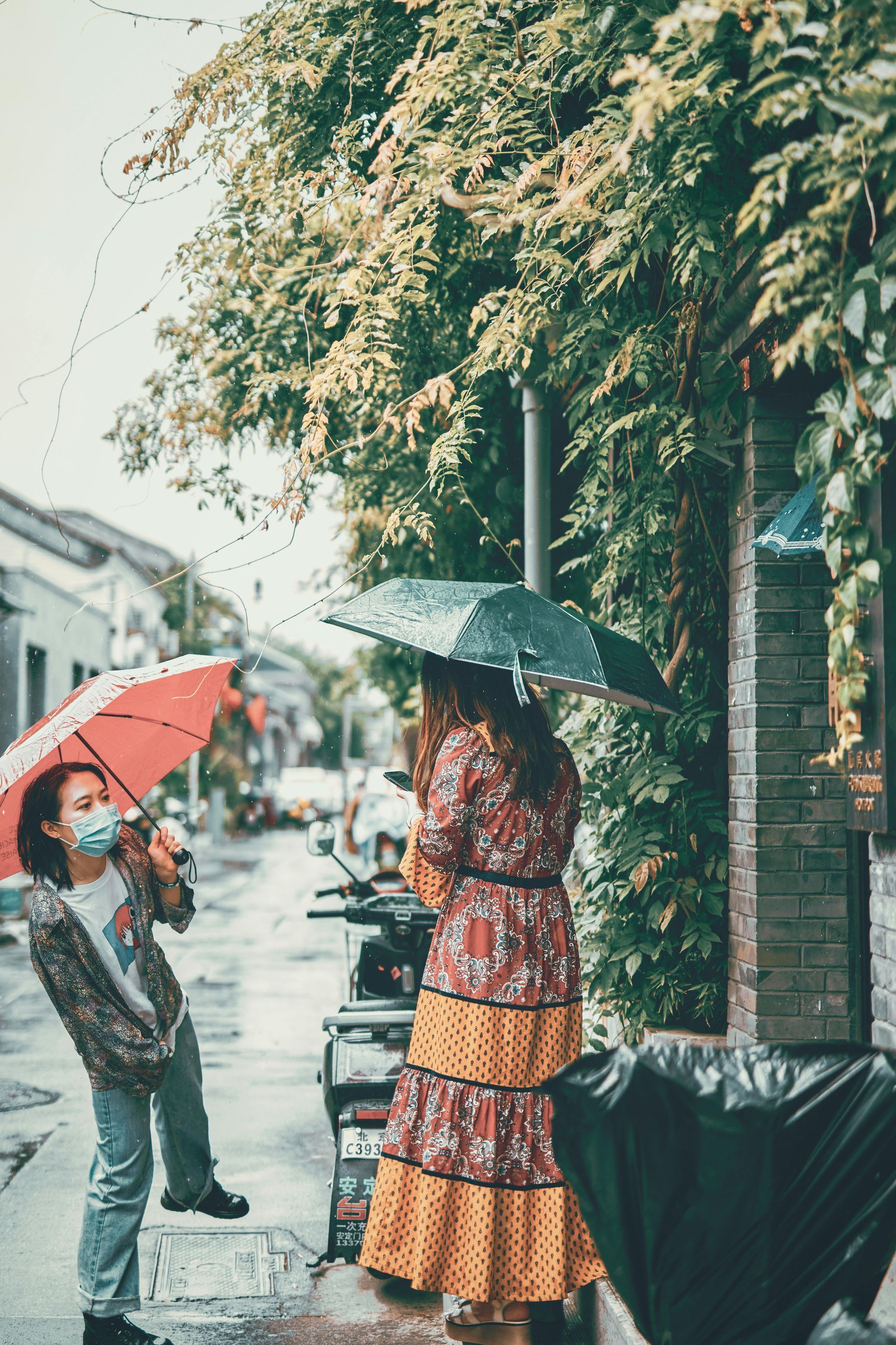 Man and woman in front of an apartment building, talking. The woman is holding a clipboard.