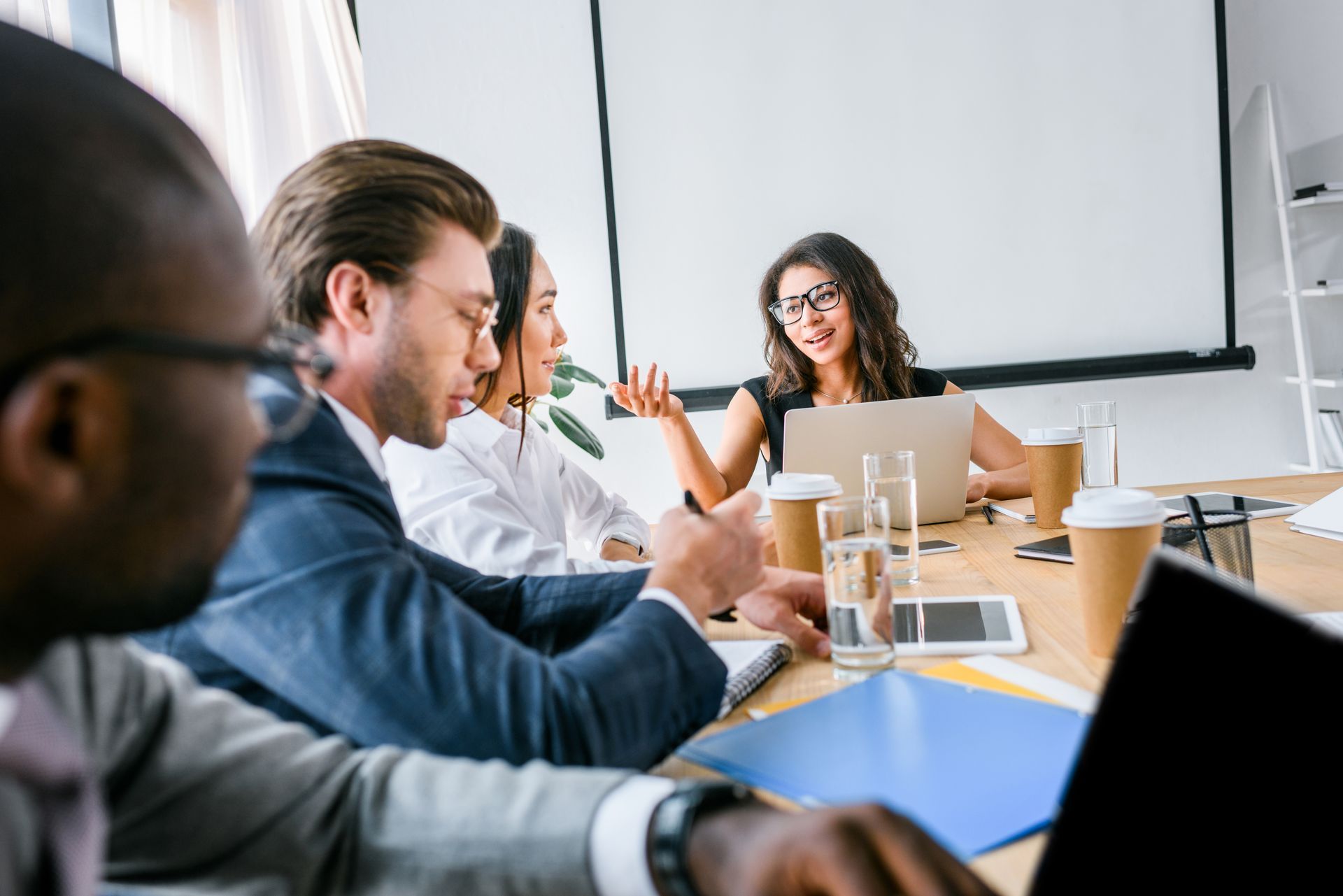 Man and woman in front of an apartment building, talking. The woman is holding a clipboard.