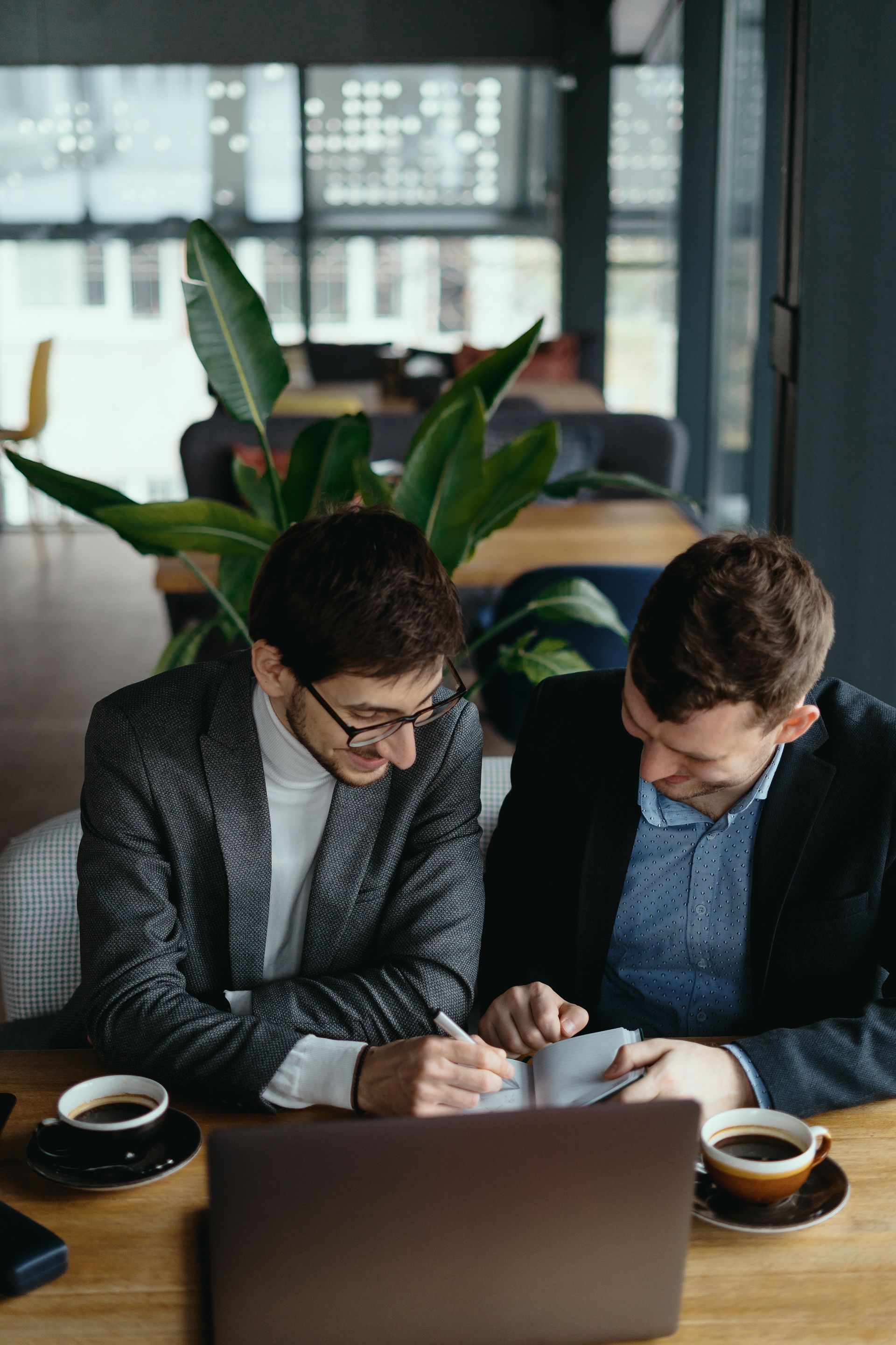 Downtown Los Angeles skyline at dusk with illuminated skyscrapers and palm trees.