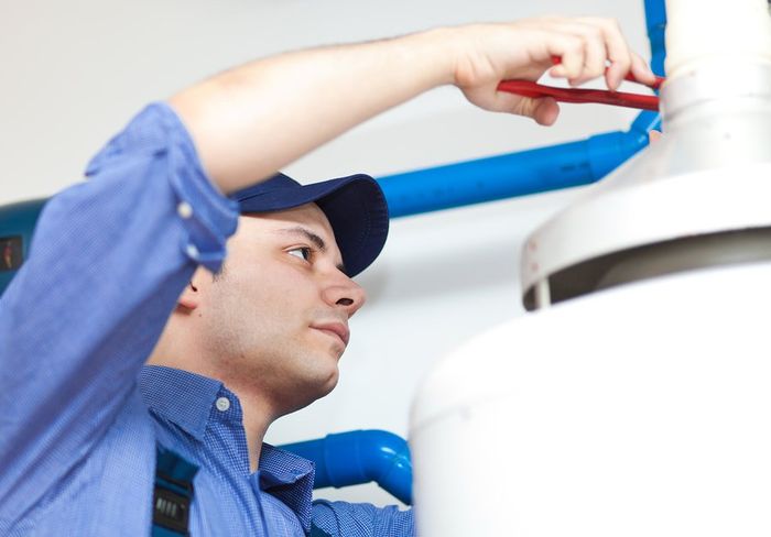man wearing his working clothes is installing boiler