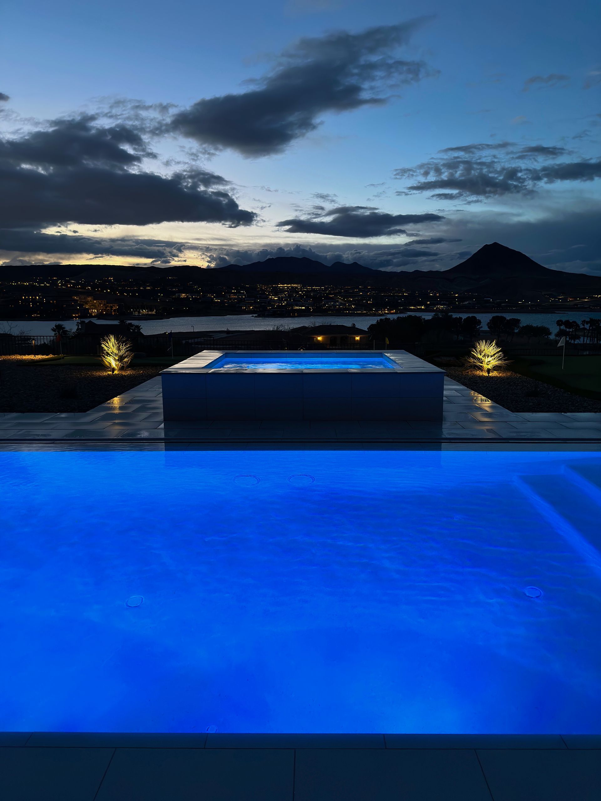 A large swimming pool is lit up at night