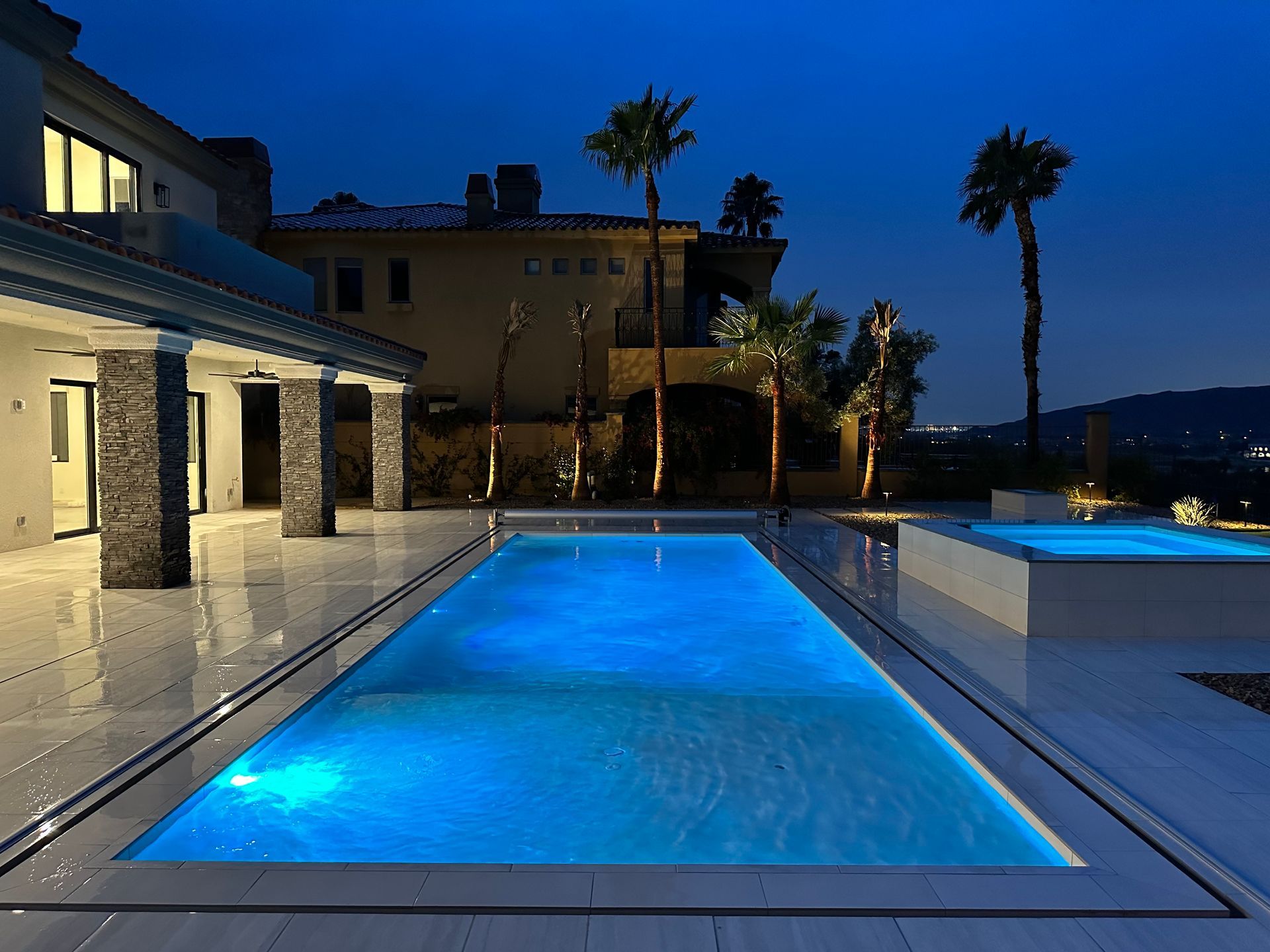 A large swimming pool is lit up at night