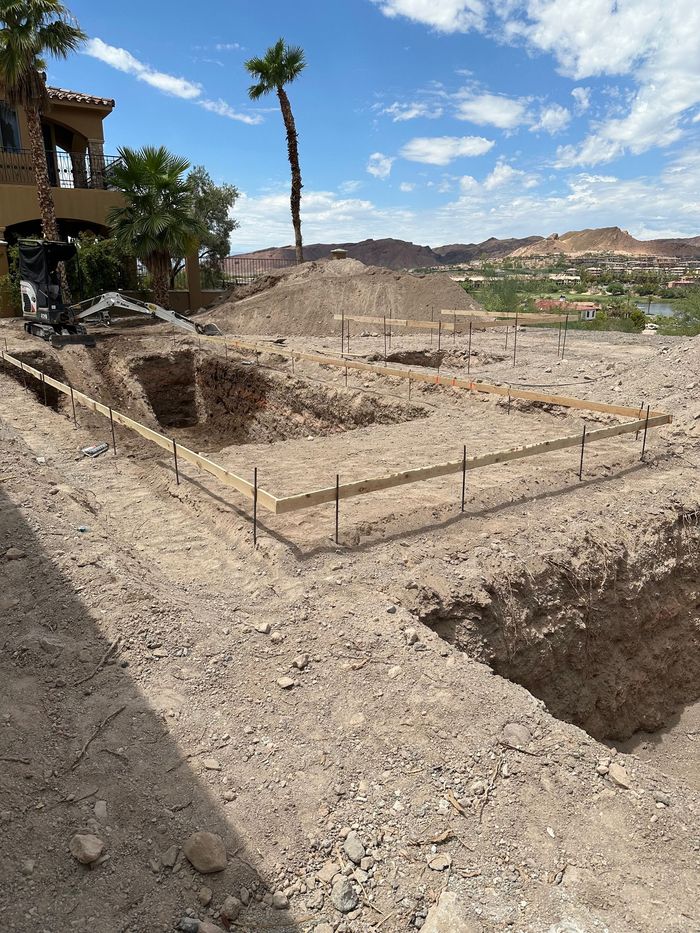 A construction site with a house in the background