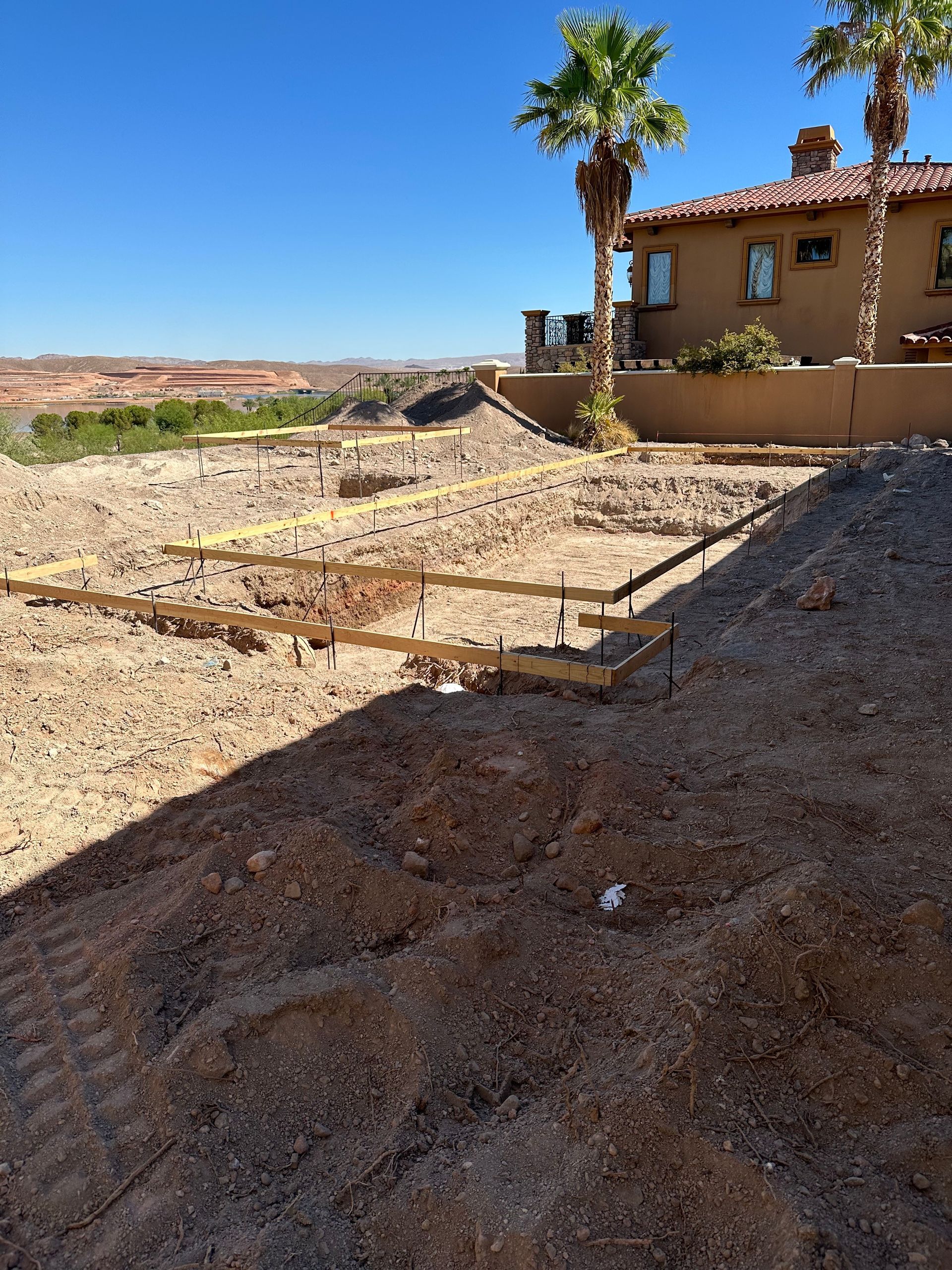 A dirt field with a house in the background