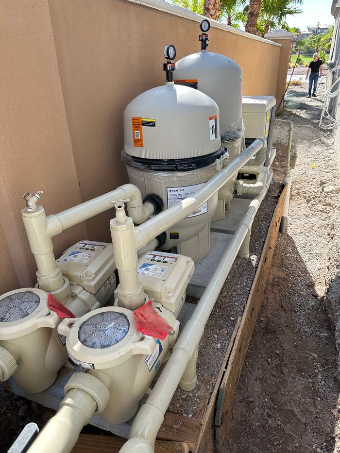 A row of swimming pool pumps are sitting on top of a wooden box.