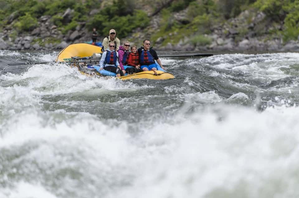 Group of People Rafting Down a River with Strong Current