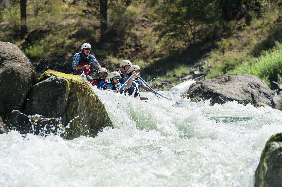 People Rafting Down a Rocky River