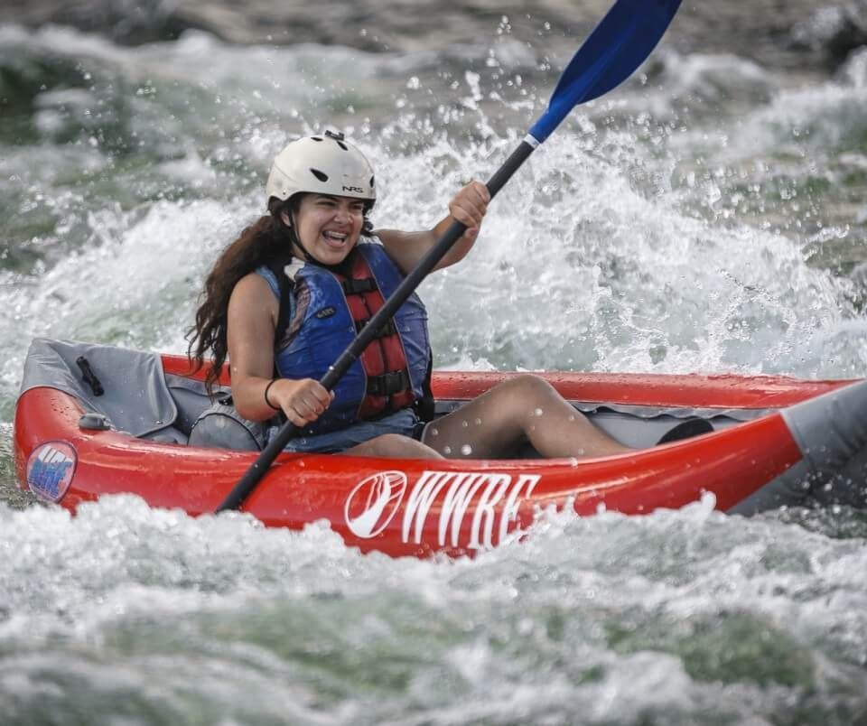 Woman Paddling a Red Kayak in A River