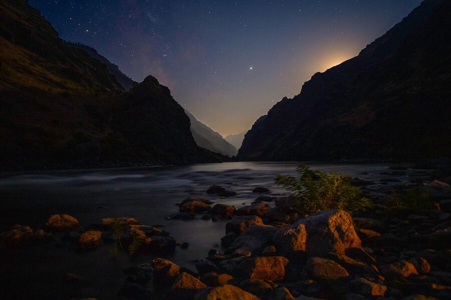 River at Night with Moon Shining Through the Mountains