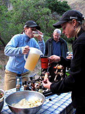 A woman pouring a pitcher of beer into a cup