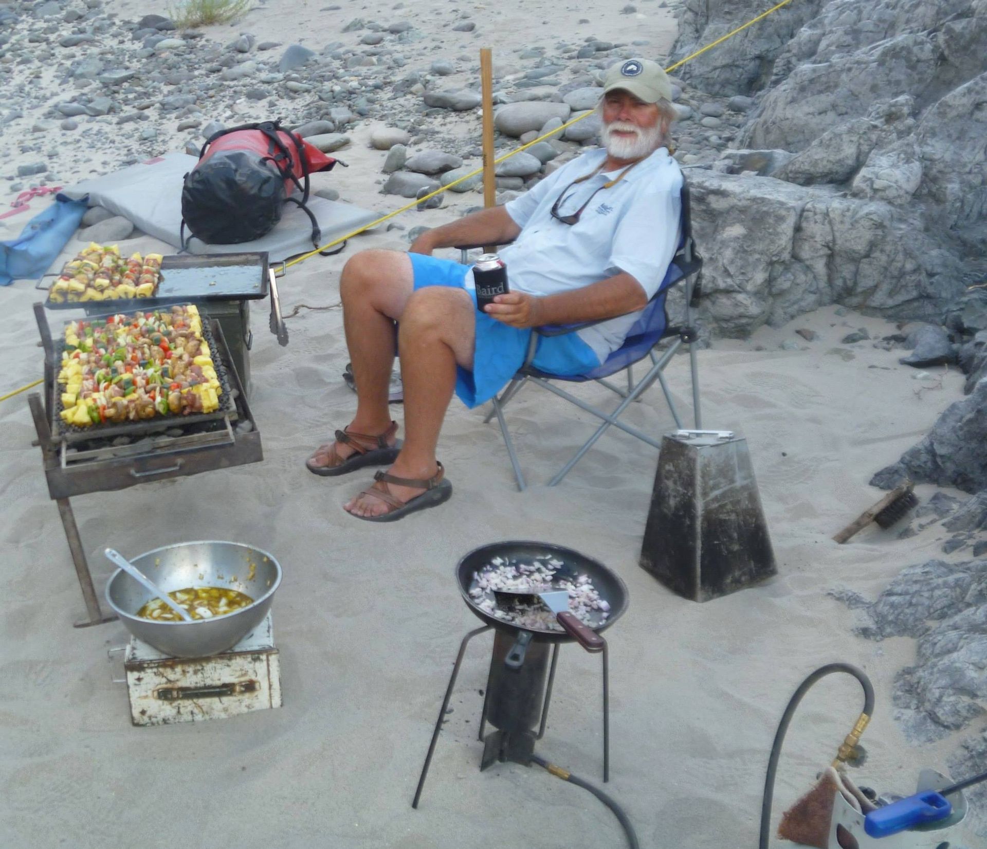 Man Sitting in A Chair on the Beach Holding a Beer