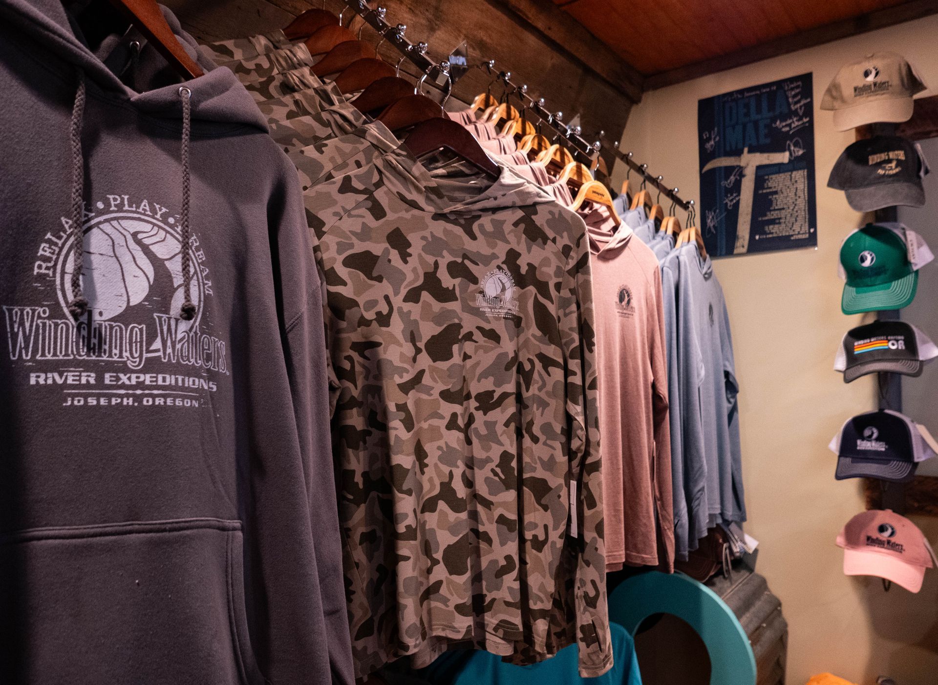 A bunch of shirts and hats are hanging on a rack