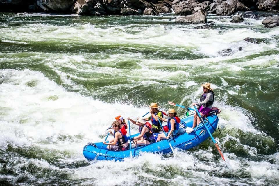 Group of People Rafting Down a River with Strong Current