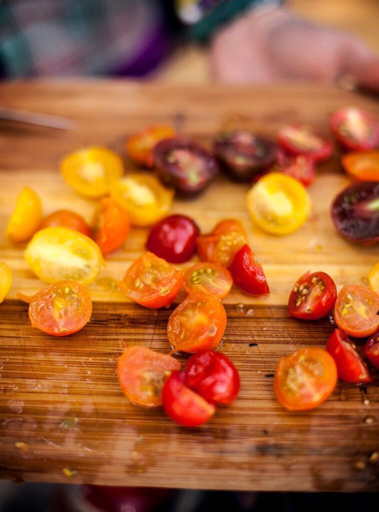 Person Cutting Cherry Tomatoes on A Wooden Cutting Board