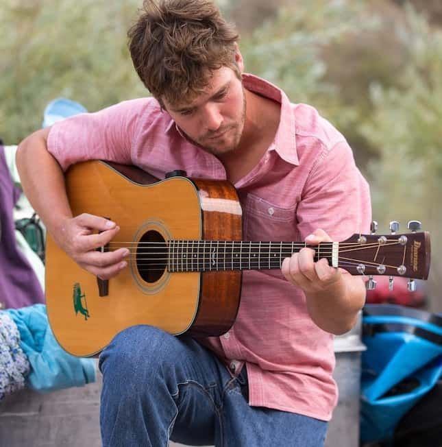 Man in A Pink Shirt Is Playing an Acoustic Guitar