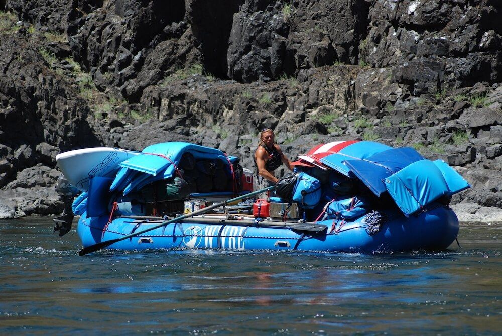 Man Standing in A Blue Raft on A River