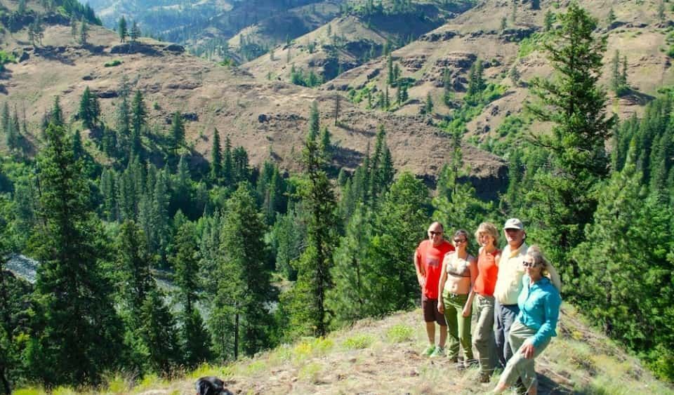 Goup of People Standing on Top of A Hill with Trees in Background