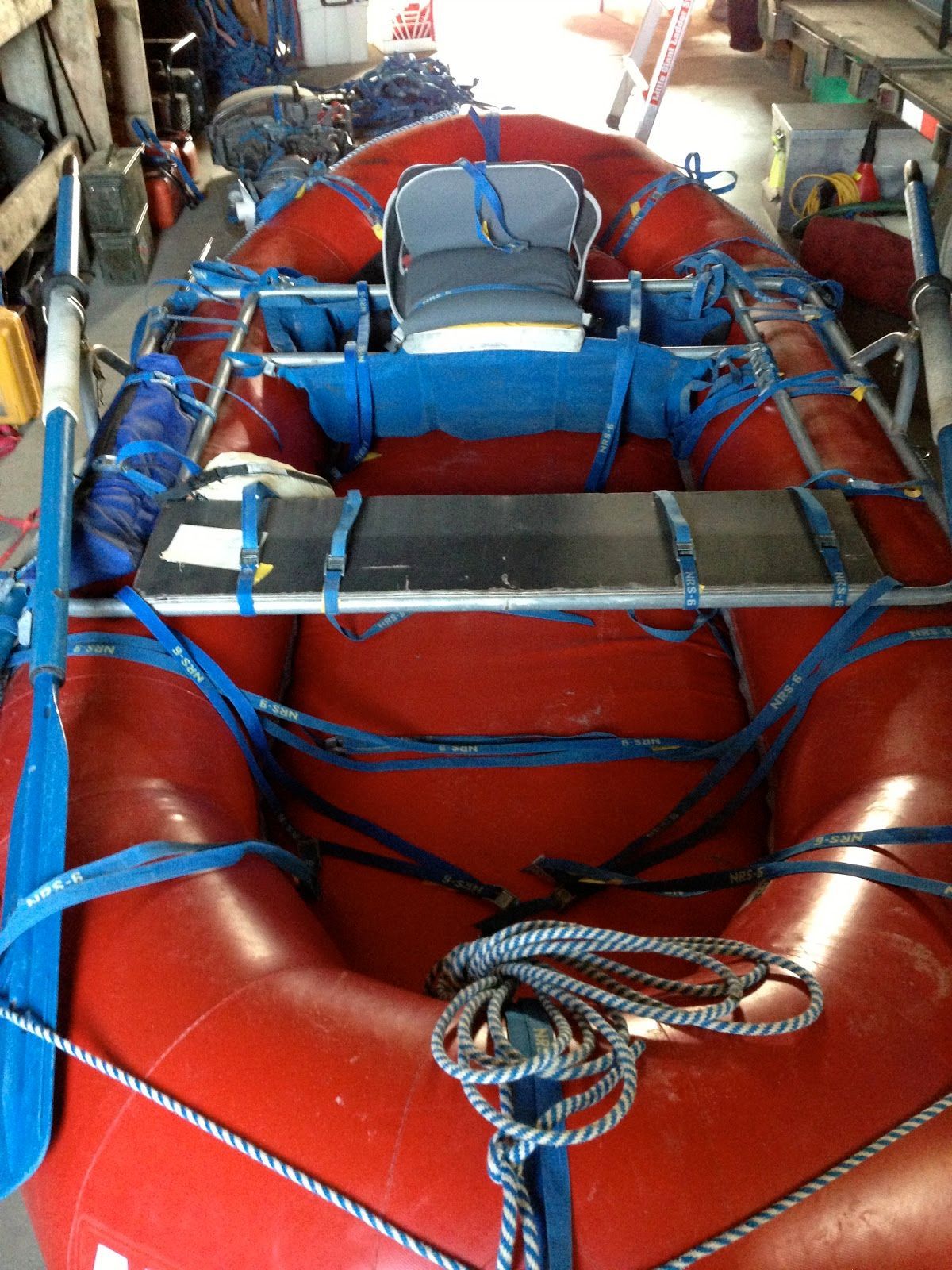 A red raft with a seat and oars in a garage