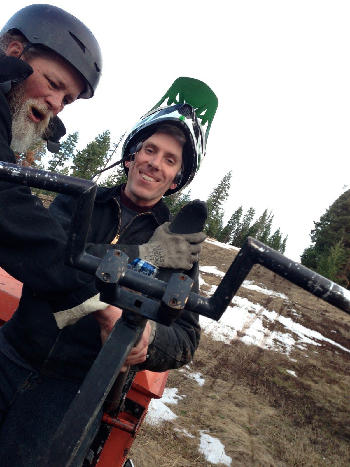 Two men wearing helmets are standing next to each other