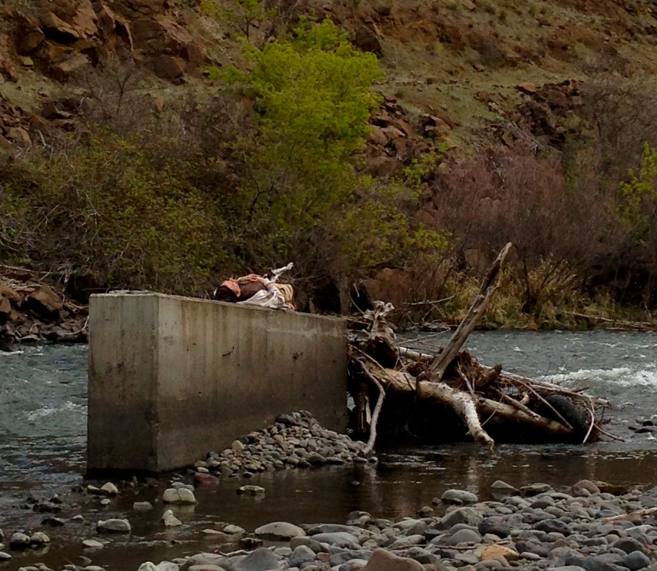 A river with a concrete block in the middle of it