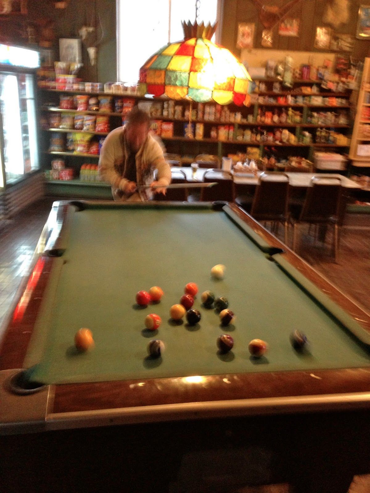 A man is playing pool in a dark room