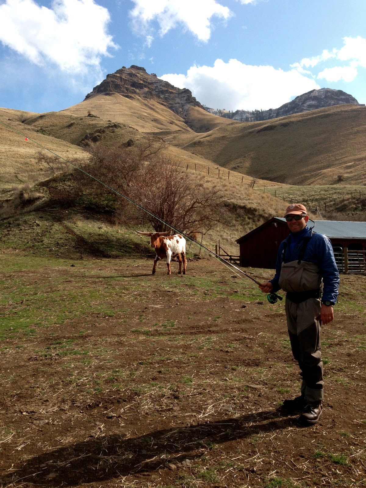 A man standing in a field with a horse in the background