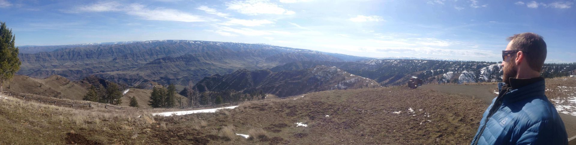 Man Standing on Top of A Hill Looking at The Mountains