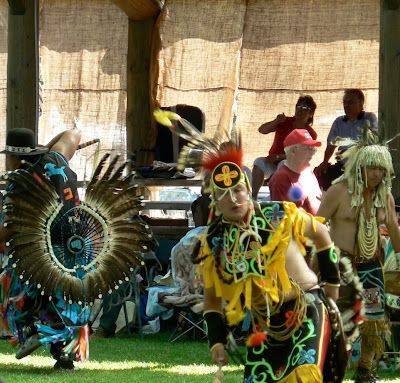 A group of people in native american costumes are dancing