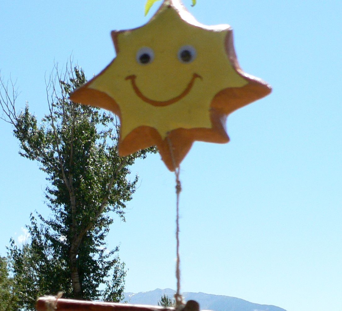 A yellow star with a smiling face is hanging from a string