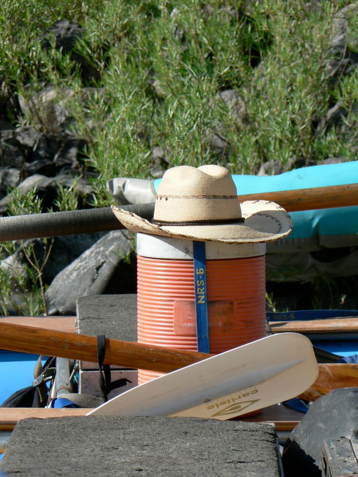 A straw hat is sitting on top of an orange can