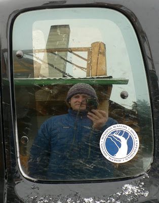 A man is taking a picture of himself in a car window