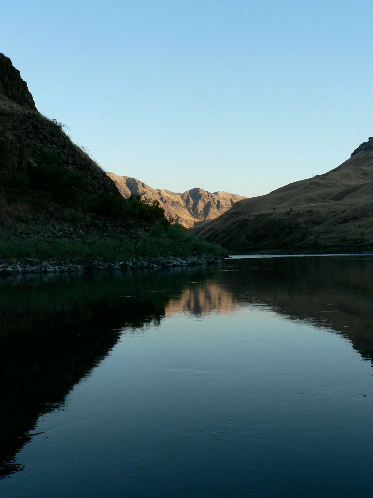 A lake with mountains in the background and a blue sky