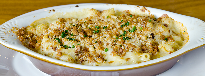 A casserole dish filled with macaroni and cheese and bread crumbs.