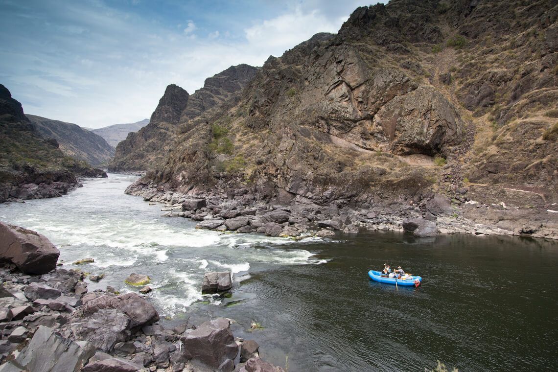 Aerial View of Blue Raft Floating Down a River in the Middle of A Canyon