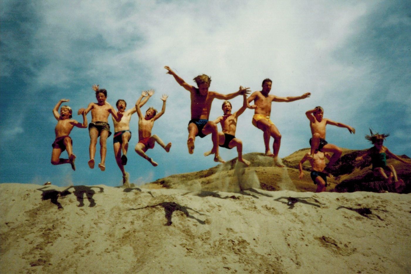 Group of people are jumping in the air on a beach