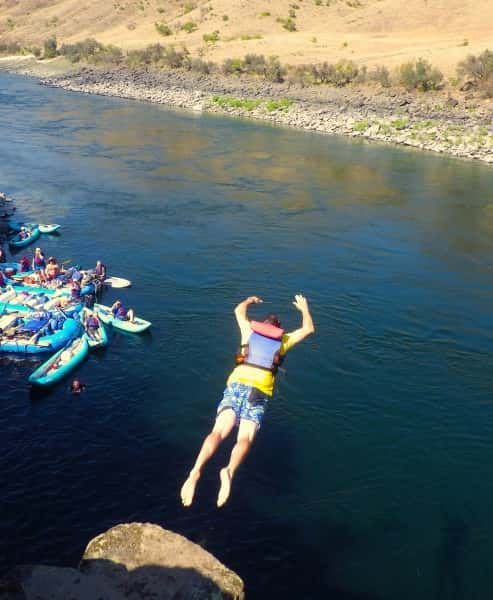 Man in A Life Jacket Is Jumping Into a River