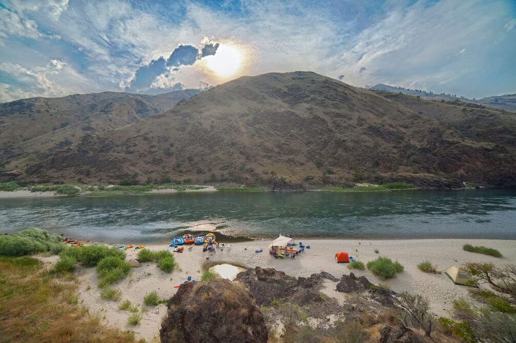 Group of People Camping Next to A River