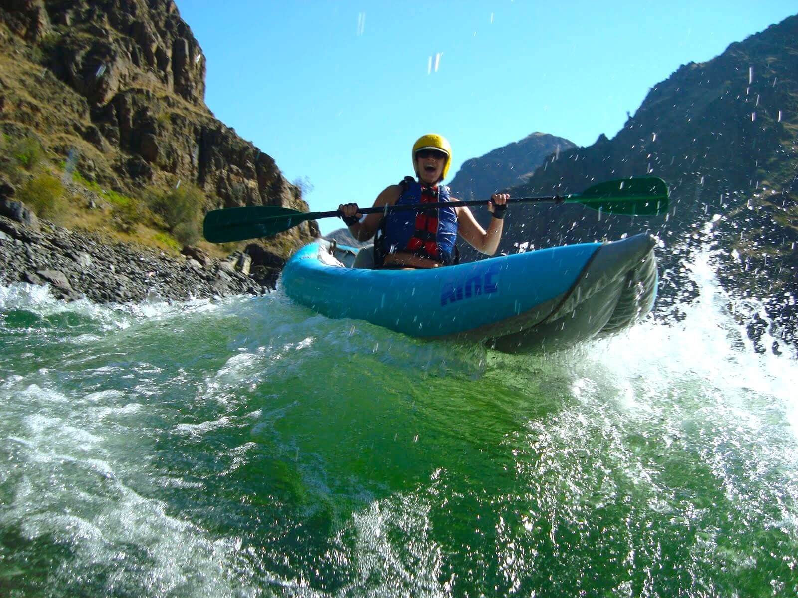 A person rafts in an inflatable kayak