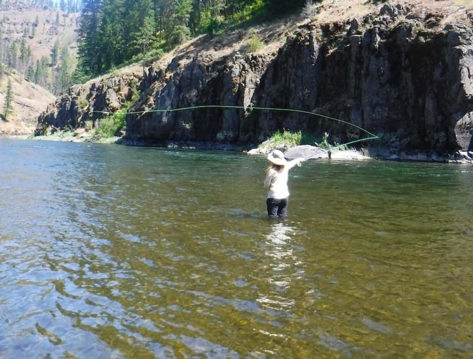 Person with A Hat Fishing in A River