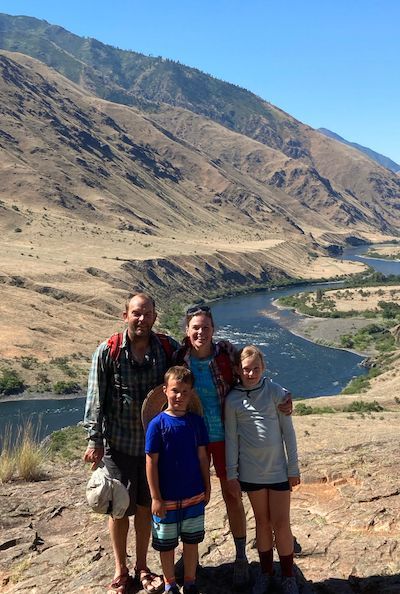 A Family Is Posing for A Picture on Top of A Mountain